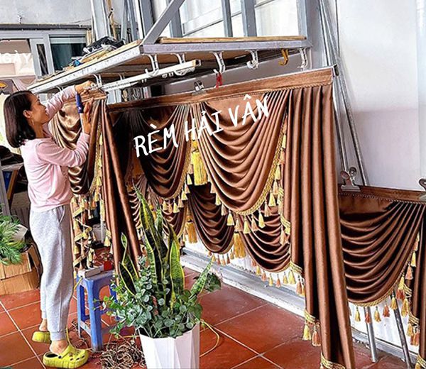 thợ may đang đính phần tua lên phần yếm sò tân cổ điển tại xưởng