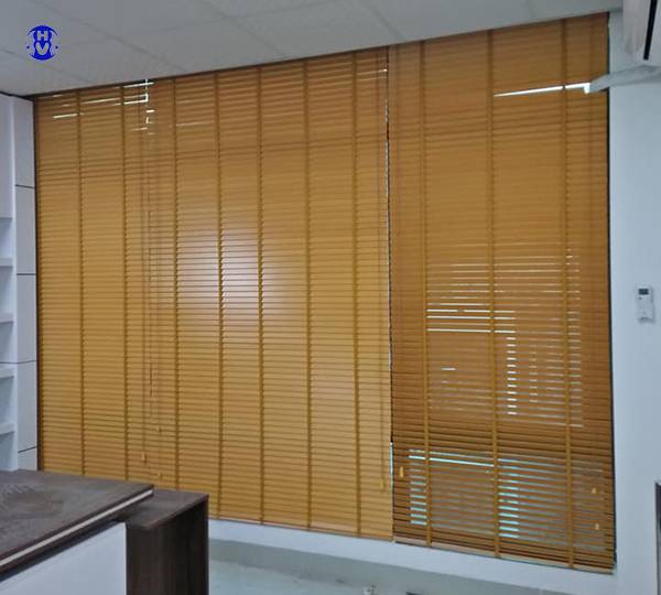 Rèm gỗ màu tự nhiên lắp trong khung cửa sổ của văn phòng
